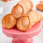 close up of cannoli shells on a small pink stand