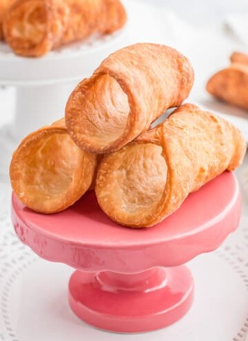 close up of cannoli shells on a small pink stand