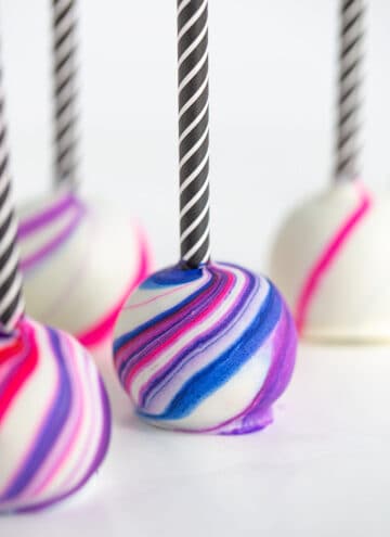a cake pop with blue, purple, and pink marbling on it