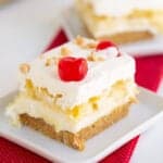 square image of a slice of cake on a white square plate with a second slice behind it in the photo