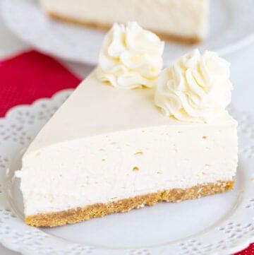 cheesecake on a small white plate with a red linen under the plate