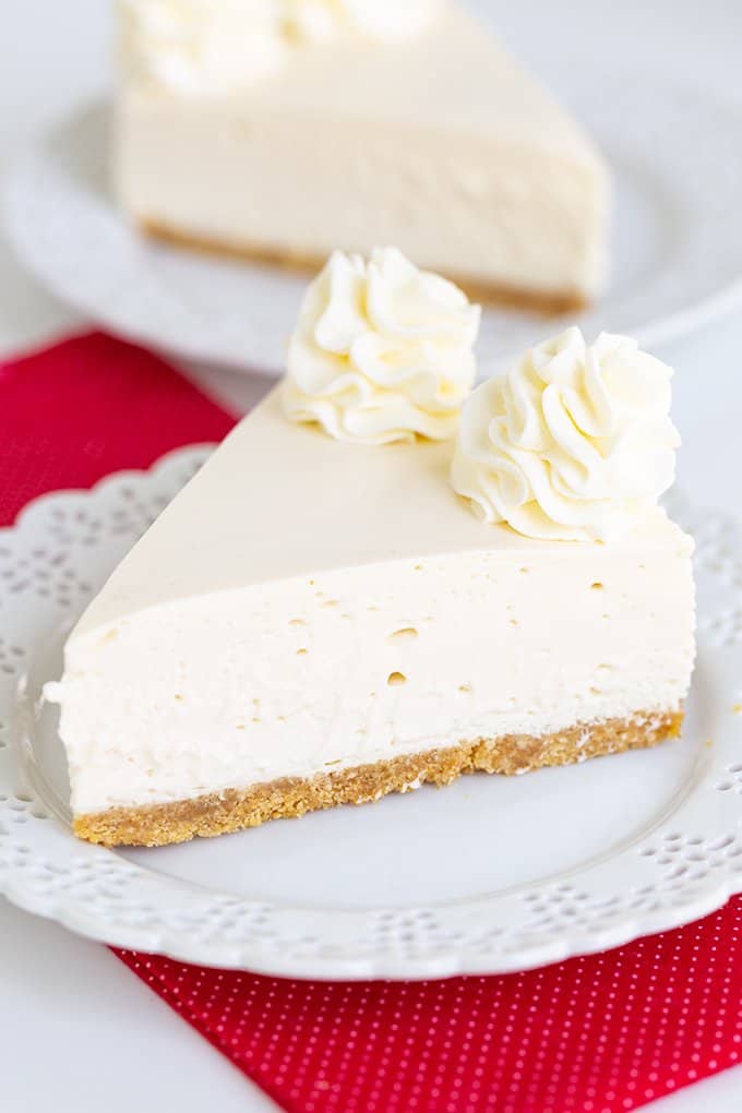 cheesecake on a small white plate with a red linen under the plate