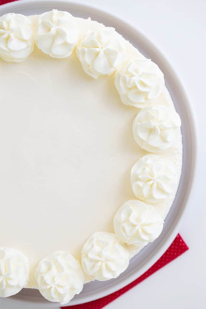 overhead image of a no bake cheesecake on a white platter on a white surface