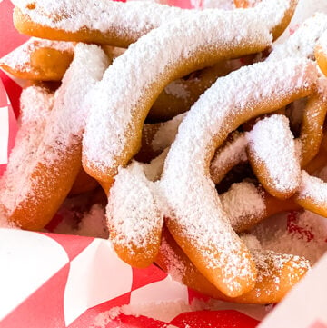 funnel cake fries on a checked piece of wax paper