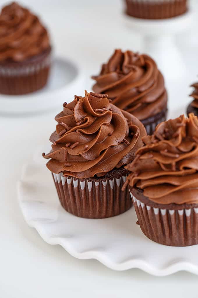 chocolate cupcakes on a white ripped serving plate on a white surface