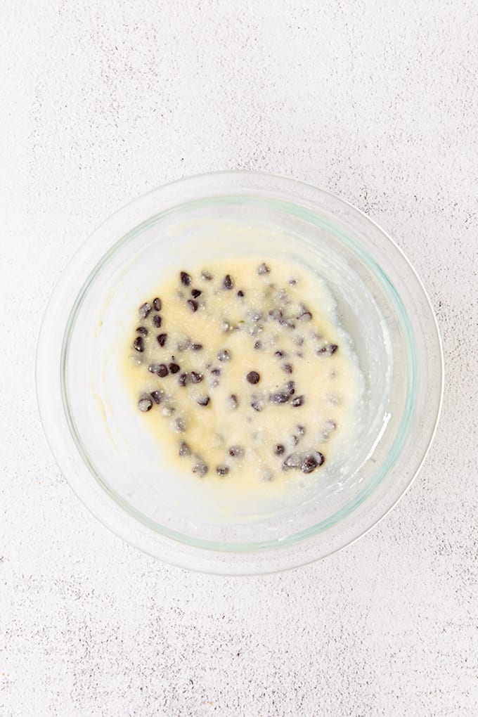 glass bowl full of ricotta cannoli filling on a gray surface