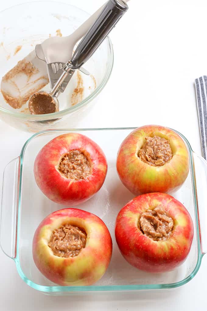 apples filled with crisp filling in a clear glass square dish on a white surface