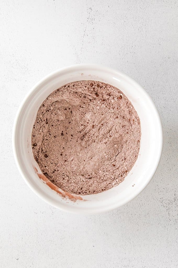 overhead photo of dry ingredients mixed together in a white bowl with a white/gray background