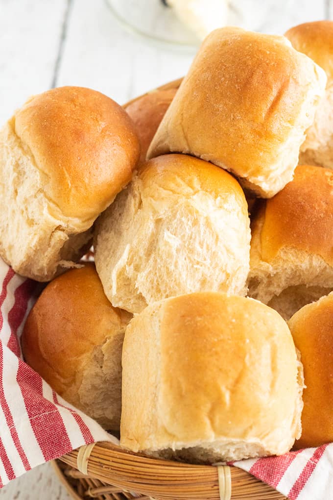 basket full of dinner rolls with a red and white linen