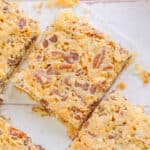 Four squares of graham cracker bars with pecans on top, sprinkled with chocolate chips.