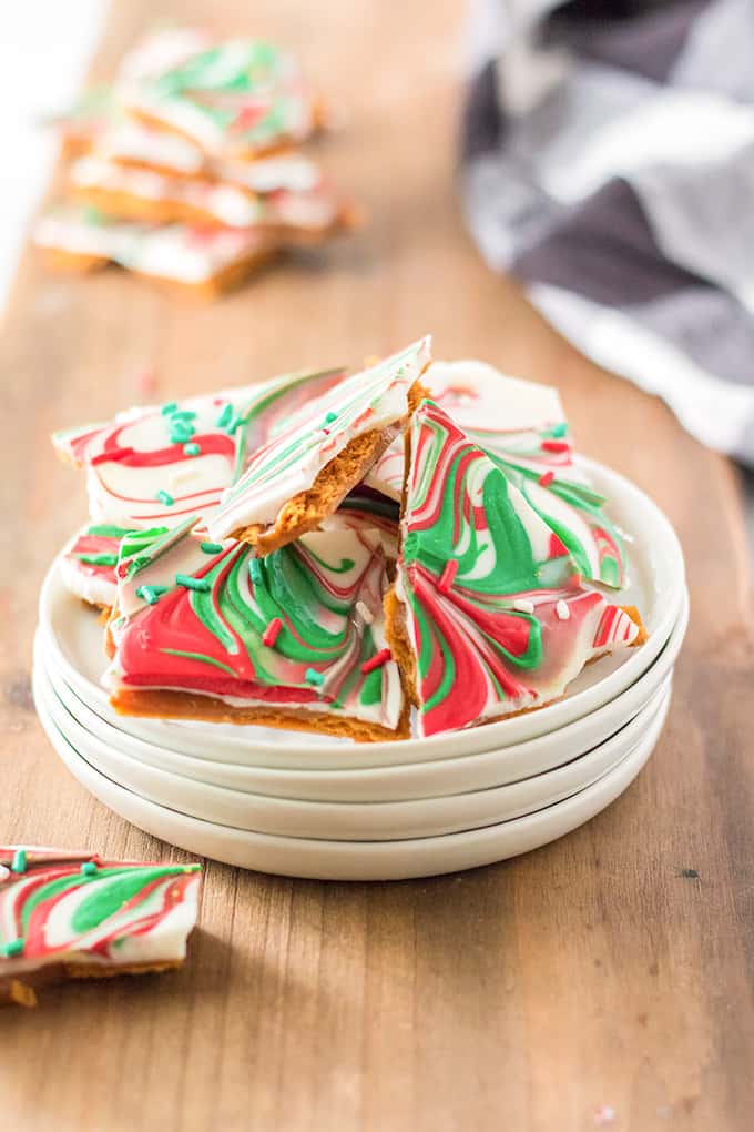 stack of white plates with ritz cracker candy on it on a wooden surface