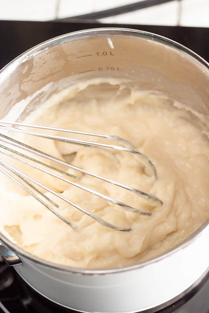 saucepan on the heat with the bread starter and a whisk in the saucepan