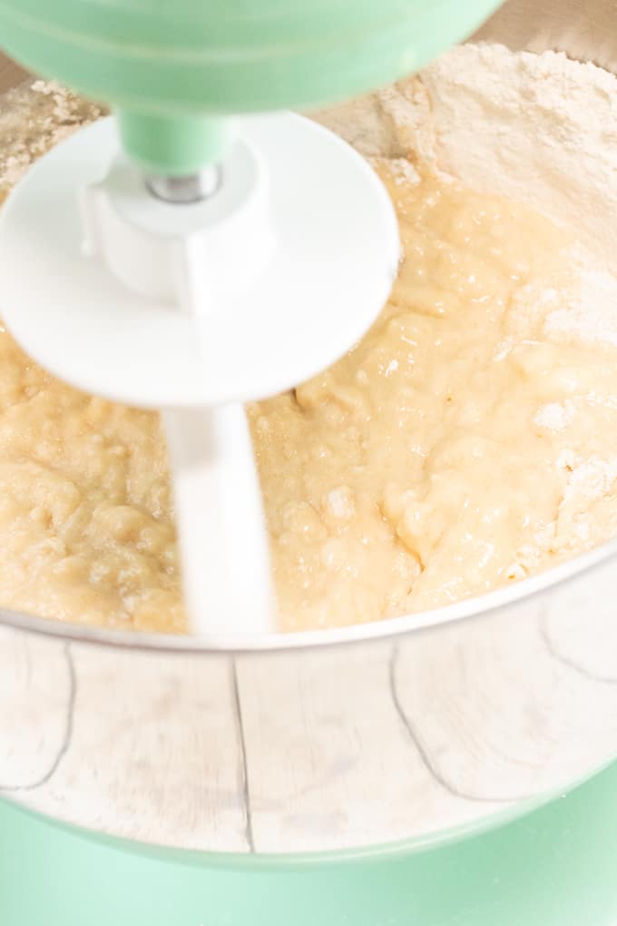 bread dough being mixed in a green kitchenaid stand mixer