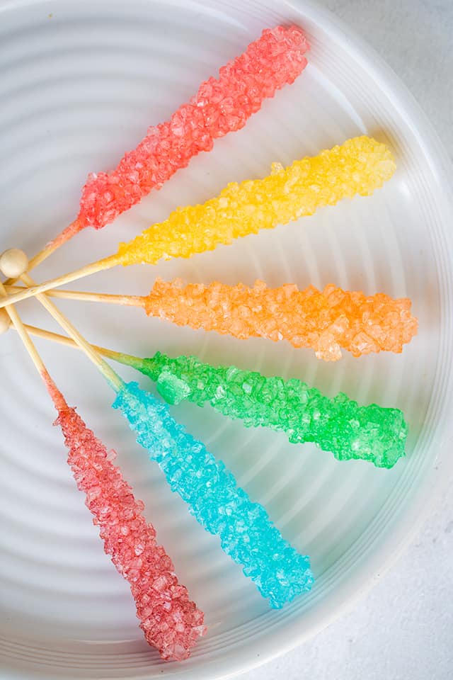 overhead photo of rock candy on a white plate on a white surface