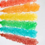 holding sticks of rock candy in the air with a white background