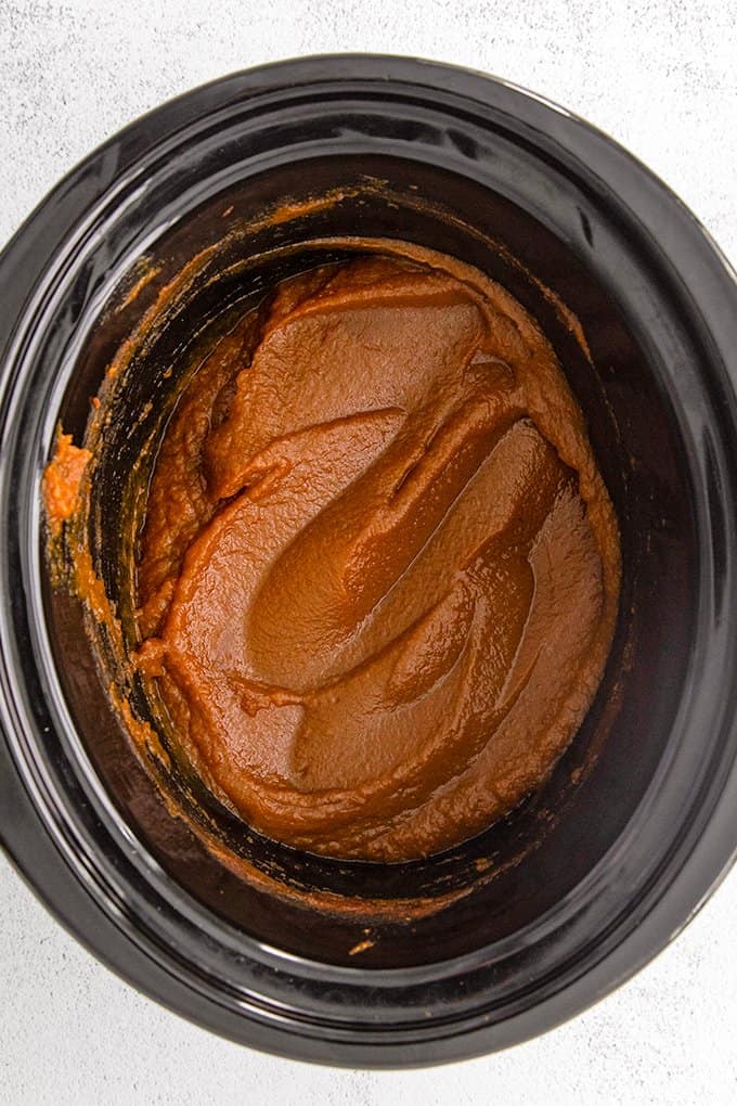 overhead image of pumpkin butter in a black crockpot insert