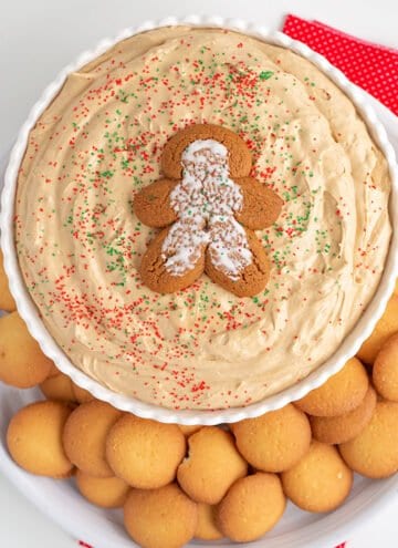 overhead image of the dip in a white bowl with a gingerbread cookie on top and nilla wafers around the dip
