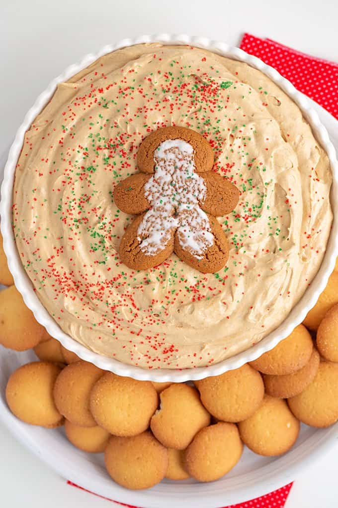 overhead image of the dip in a white bowl with a gingerbread cookie on top and nilla wafers around the dip