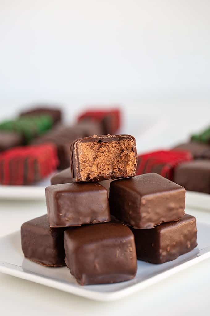 stack of candy on a white square plate with a bite taken out of the top piece