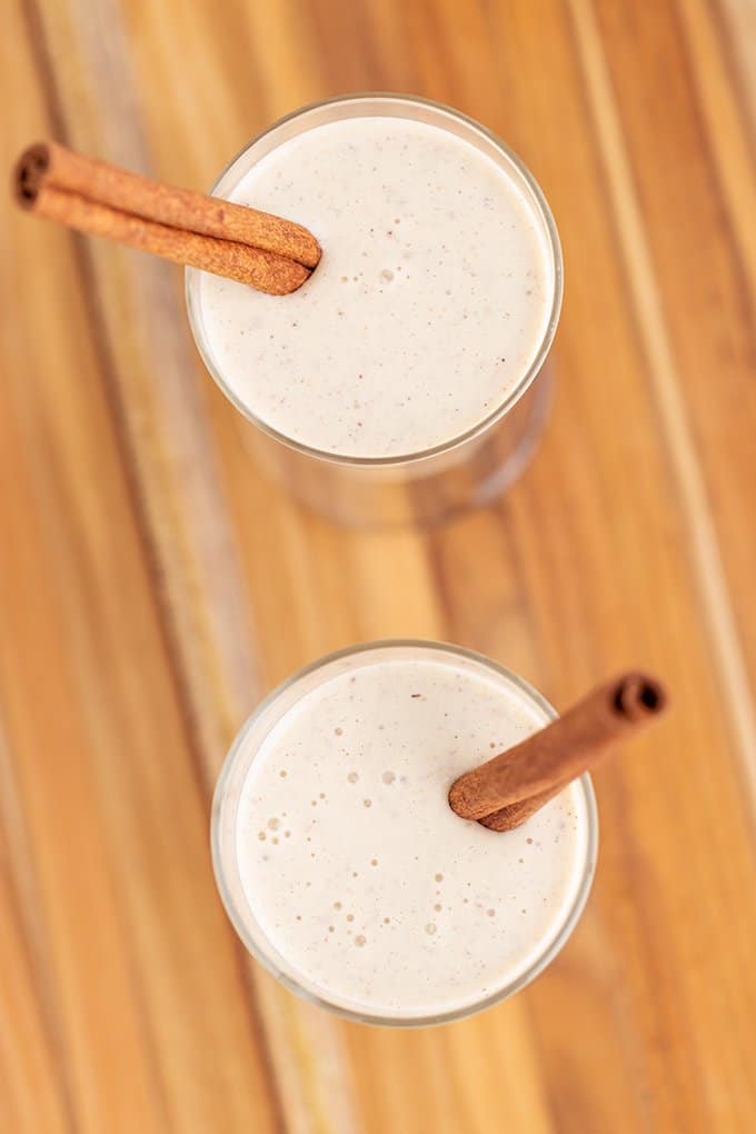 overhead view of the eggnog in glasses with a cinnamon stick