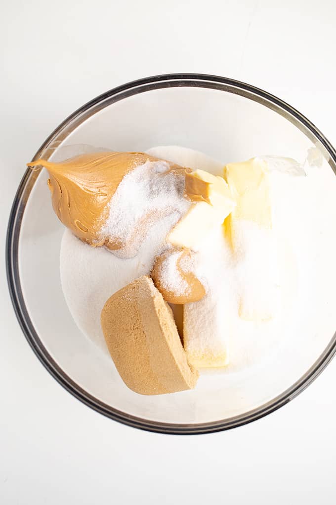 Ingredients for peanut butter cookies in a glass bowl on a white surface