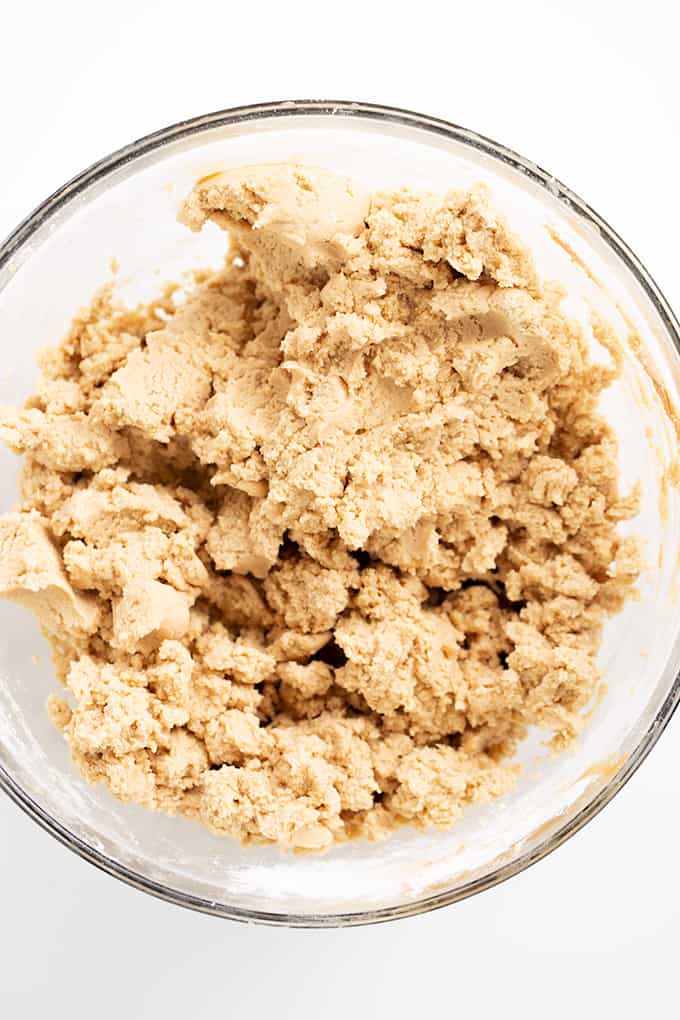peanut butter cookie dough in a glass bowl on a white counter