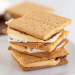 close up of the stack of s'mores on a white plate on a white background