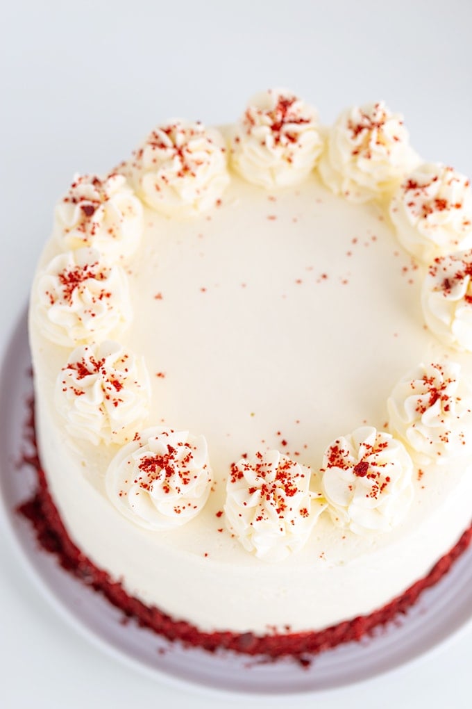 picture from above showing the cream cheese whipped cream frosting swirls and dried cake crumb garnish on a white surface