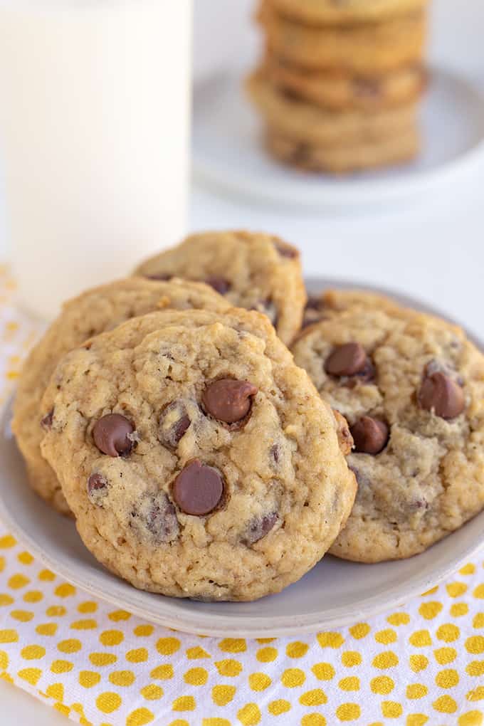 banana chocolate chip cookies on a small plate with a glass of milk behind it