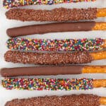 overhead image of chocolate covered pretzel rods on a white platter