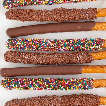 overhead image of chocolate covered pretzel rods on a white platter