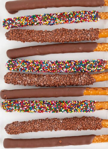 overhead image of chocolate covered pretzel rods on a white platter