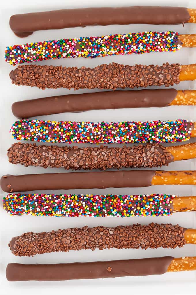overhead image of chocolate covered pretzel rods on a white platter