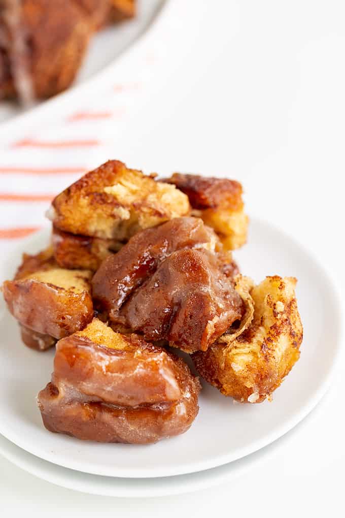 pieces of monkey bread made with cinnamon rolls on a white plate on a white surface