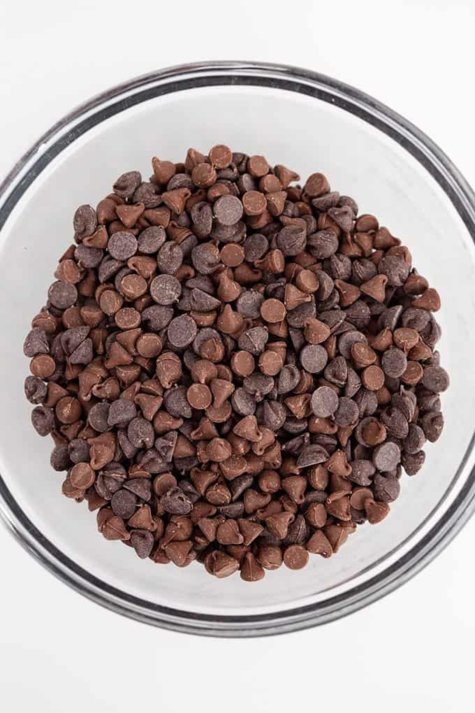 glass bowl of mixed chocolate chips on a white background