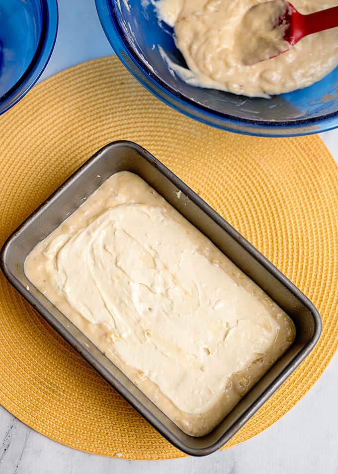 Layering the batter and cream cheese in the loaf pan.