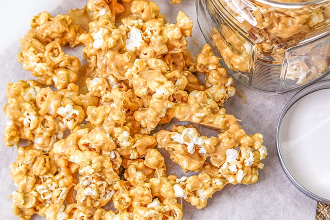 Gooey peanut butter popcorn cooling on a parchment paper.