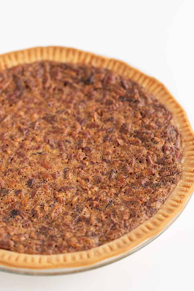 whole pecan pie on a white surface