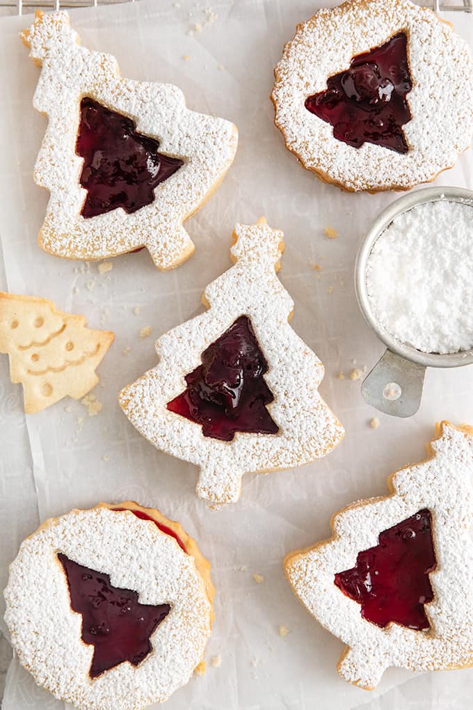 christmas tree linzer cookies on a piece of parchment paper