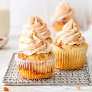 close up of the cinnamon vanilla cupcakes showing the cinnamon cream cheese frosting swirls and the cinnamon swirls inside the vanilla cupcakes