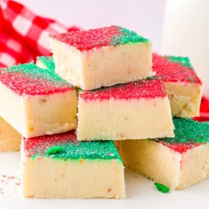 A stack of sugar cookie fudge squares with sprinkles.