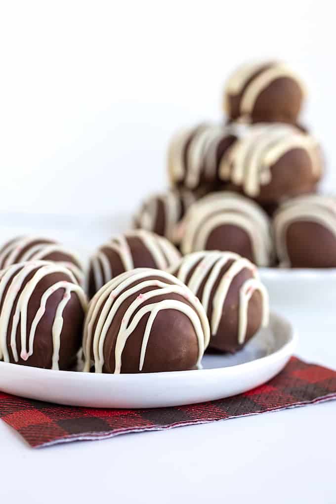 Peppermint cookie truffles on a white plate with a red and black napkin on a white surface