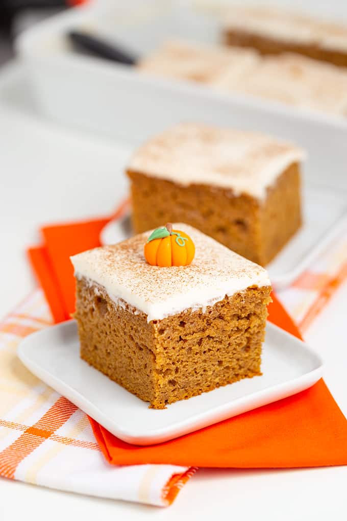 A slice of pumpkin cake displayed with orange napkins.