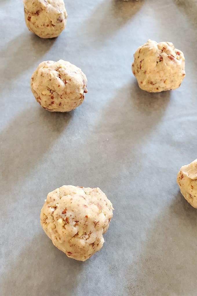 snowball dough balls on a parchment lined cookie sheet