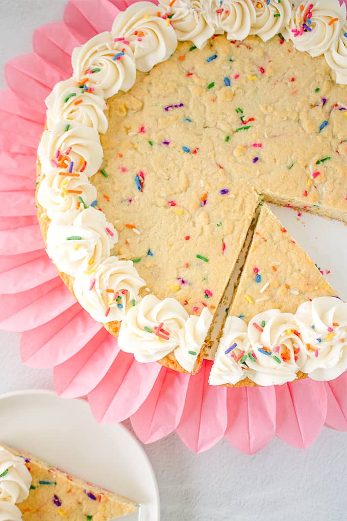 sugar cookie cake on a pink ripped tissue paper with slices cut