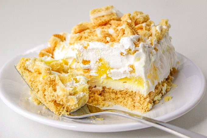 Single serving of lemon delight on a plate, bite removed, close up side view.