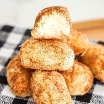 Stacked Philadelphia Irish Potato Candy with a bite taken out of the top candy on a black and white linen