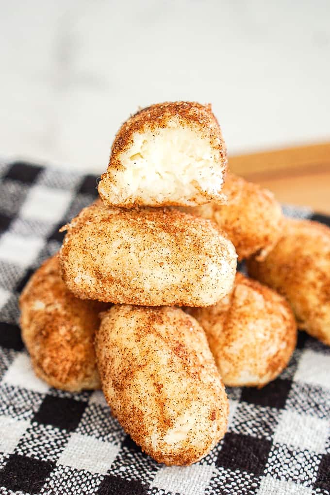 Stacked Philadelphia Irish Potato Candy with a bite taken out of the top candy on a black and white linen