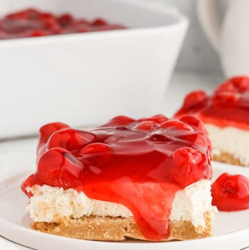 A slice of cherry cheesecake, a cherry delight, on a white plate.