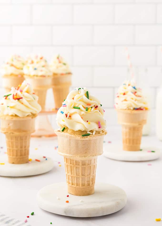 Close up of ice cream cone cupcake in focus with several in the background.